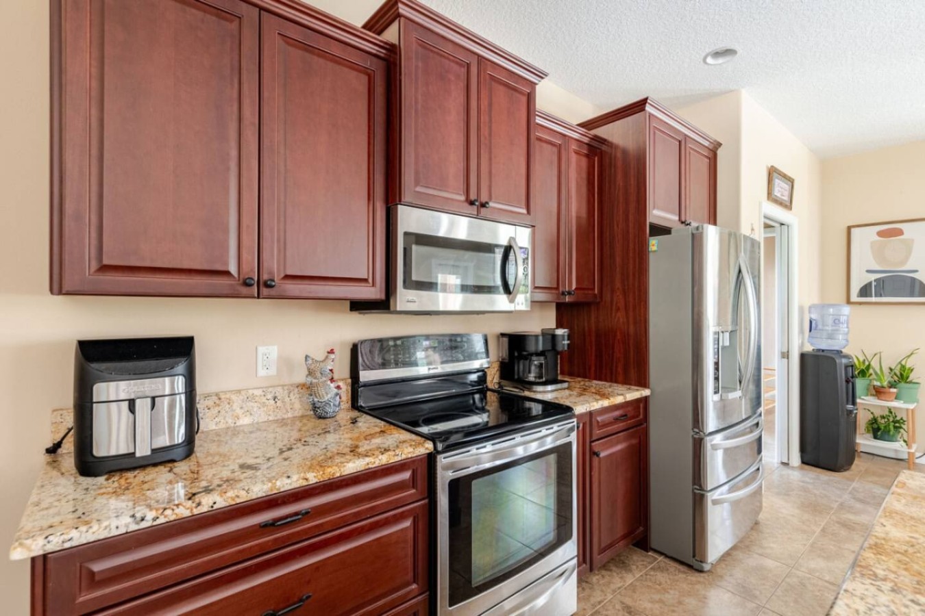 Cherry cabinets warm up this second view of the kitchen, standard appliances ready for a group's worth of meals.