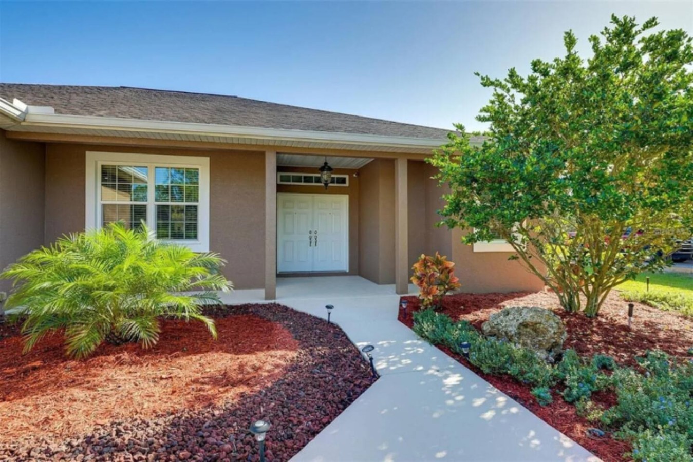 Landscaped beds frame the front walkway, tidy without feeling fussy.