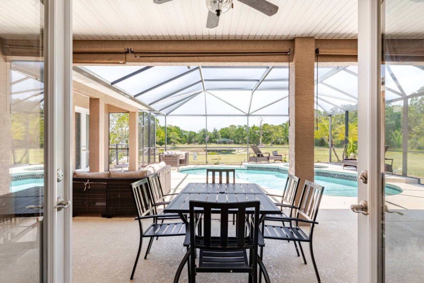 A dining table under cover, positioned for a pool view with every meal.