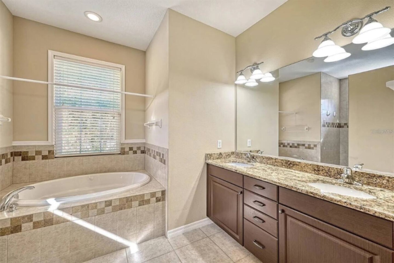 A near-identical layout in a second bathroom: tub, vanity, everyday essentials.