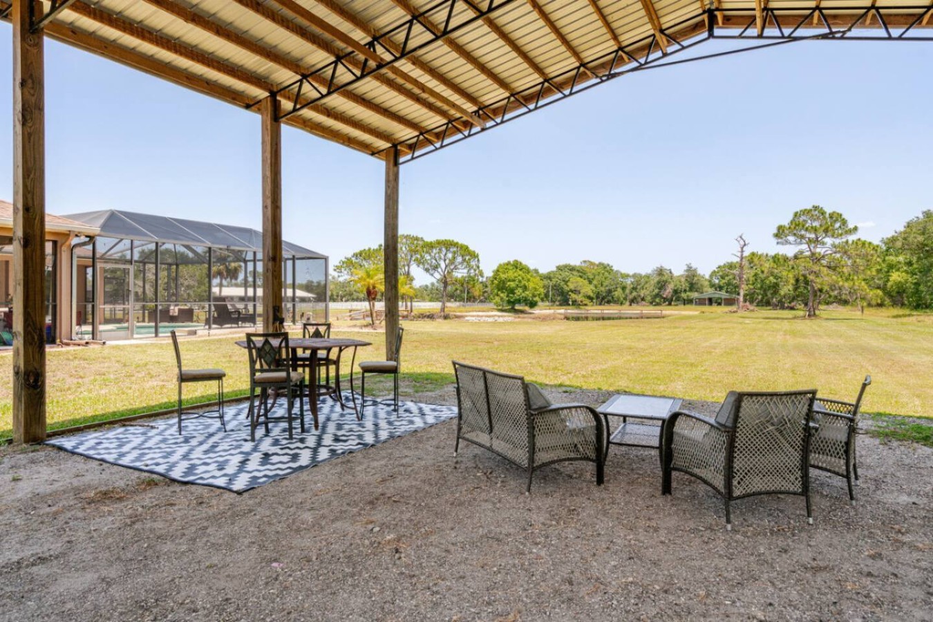 Dining moves outside under cover, pond and oaks as the backdrop for dinner.