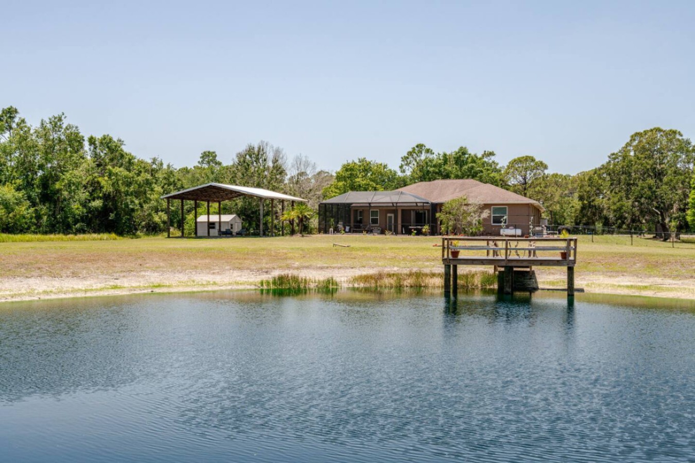 From above, the dock reaches well out into the pond, more water access than most retreat properties offer.