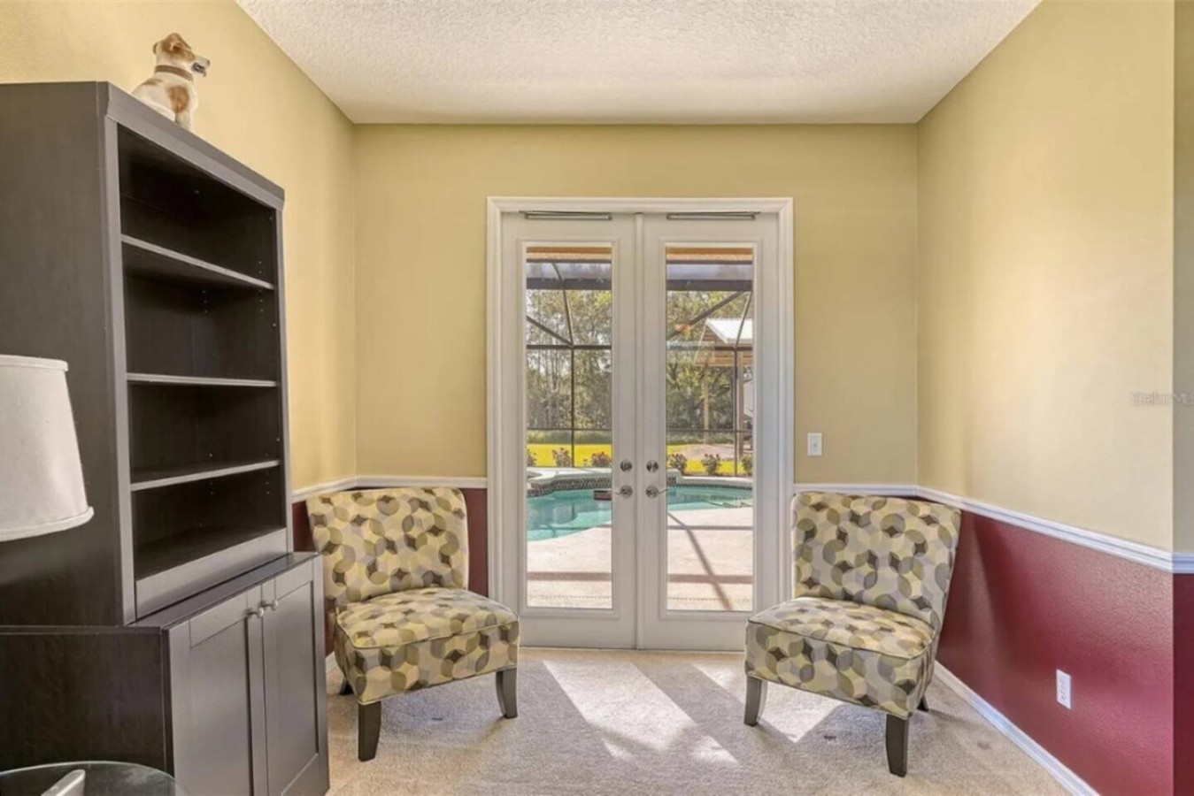 A flex sitting room with a dark wood bookcase, ready to serve as a quiet corner, a kids' space, or overflow seating.