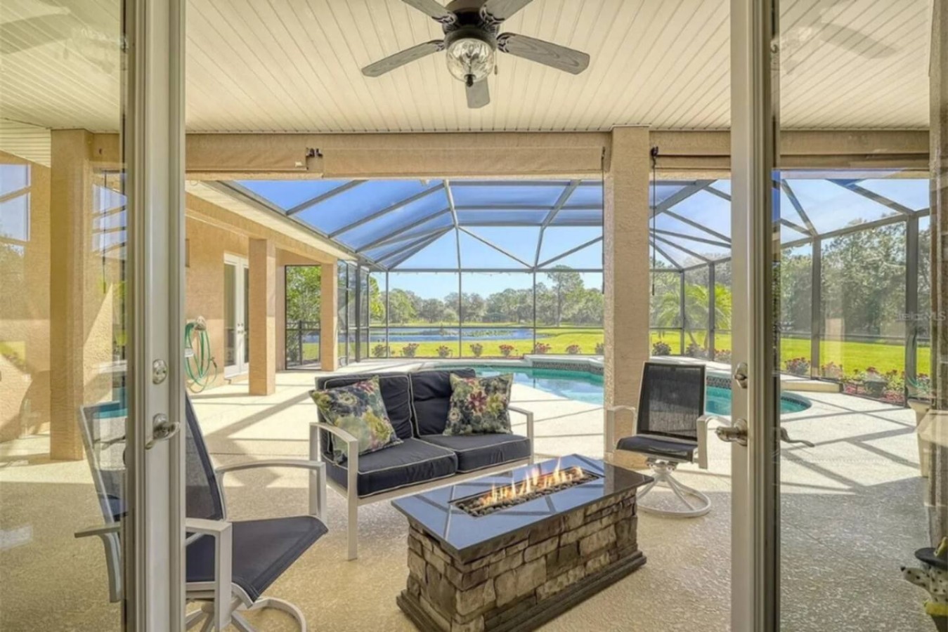 A fire pit table anchors this corner of the lanai, built for the conversations that run past sunset.
