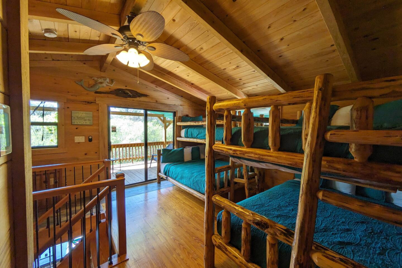 Loft bedroom with log bunk beds, opening onto the balcony