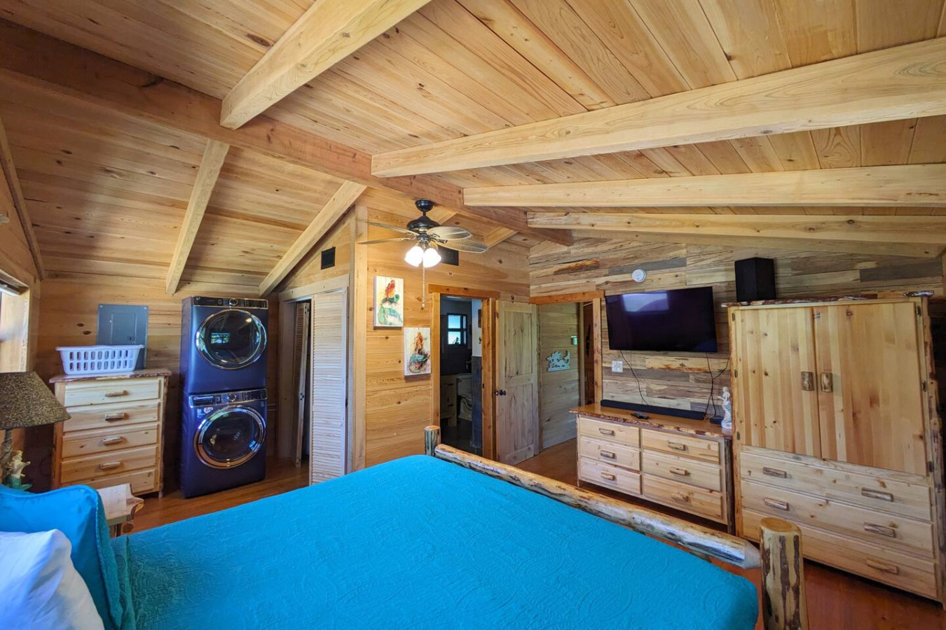 Bedroom with washer and dryer and a wall-mounted television