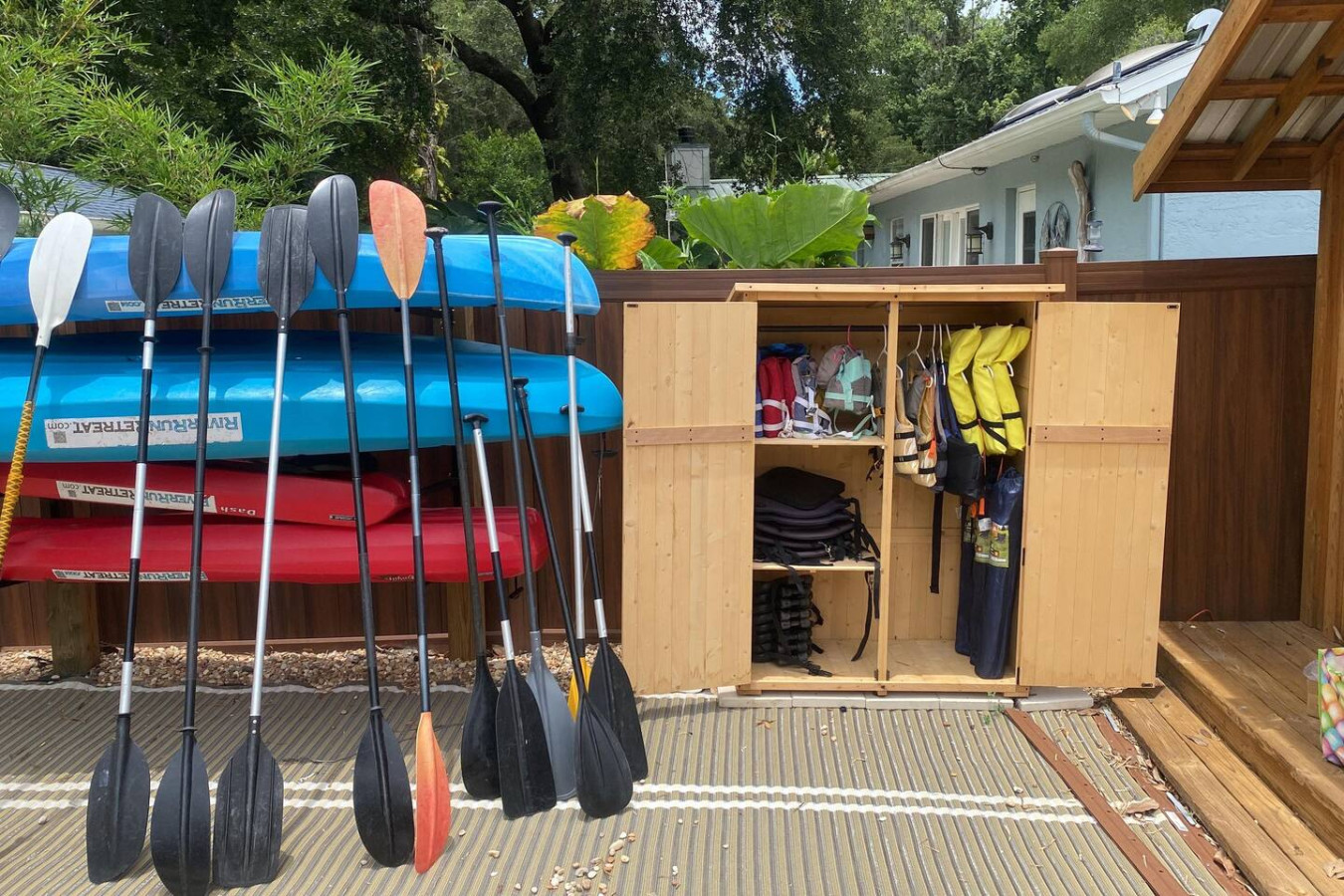 Kayaks, paddles and life jackets, ready by the shed