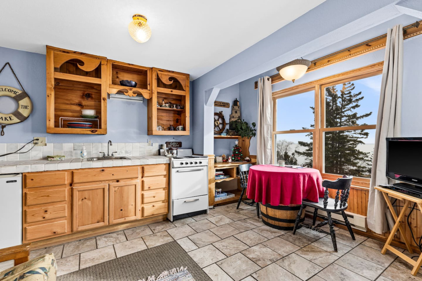 Kitchenette with efficiency range/oven, mini fridge, microwave, and coffeemaker.