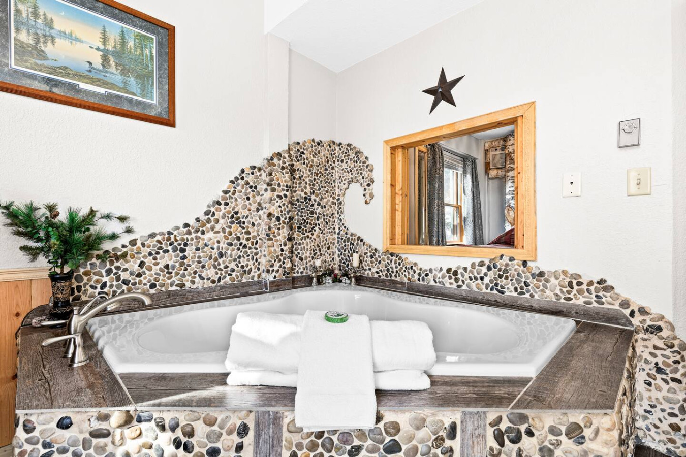 Double person jacuzzi adorned by tons of inlaid rocks.