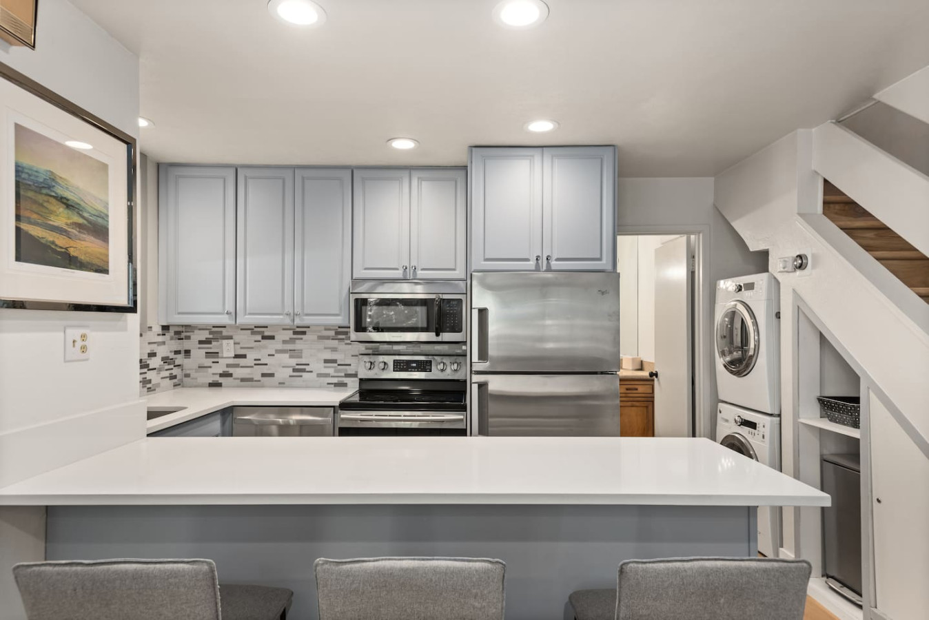 Modern kitchen with stainless steel appliances and stone countertops