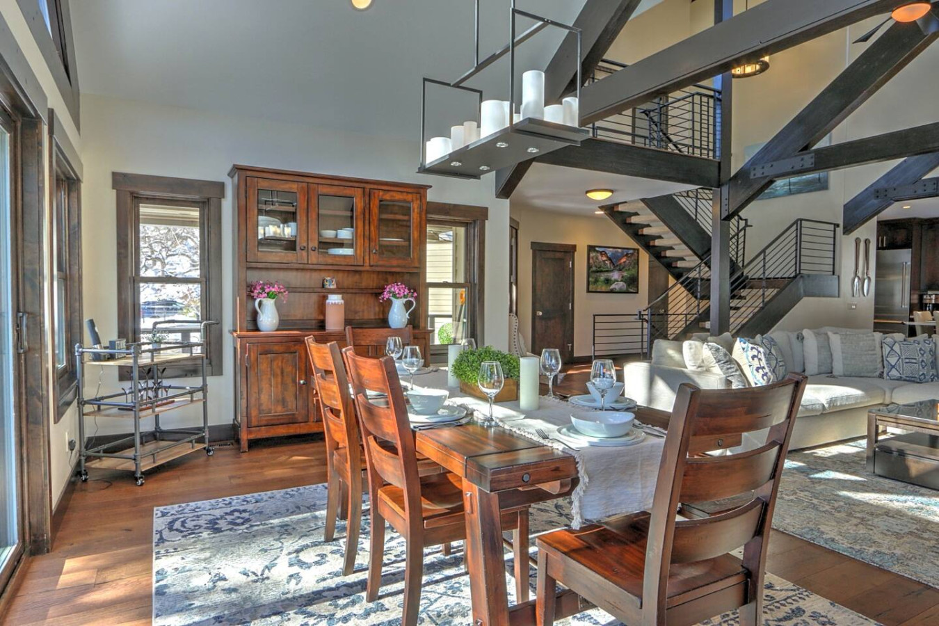 Open living and dining area with uniquely crafted beams & open staircase