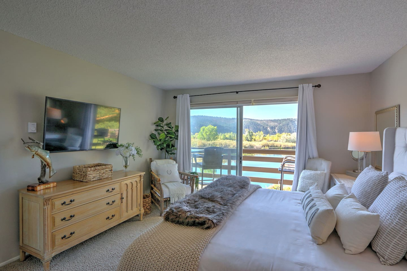 Primary bedroom with king bed, balcony access and pond views