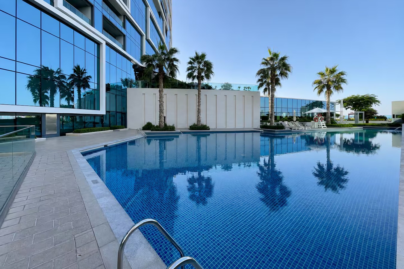Swimming Pool Oasis: Dive into luxury with stunning views and palm-lined relaxation areas!