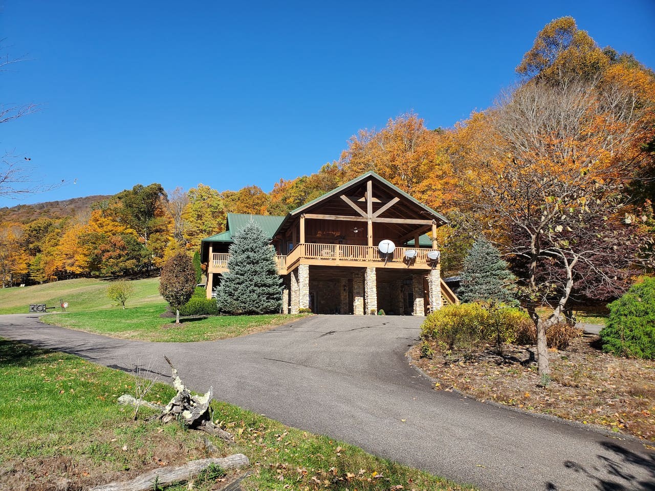 Timber-frame mountain house with a covered deck, in autumn, West Jefferson, NC