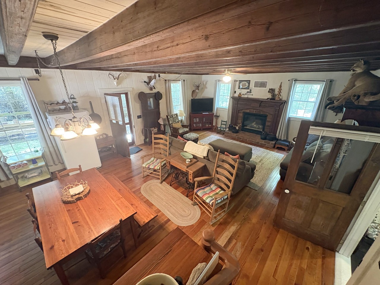 Great room with beams, dining table and fireplace.jpg