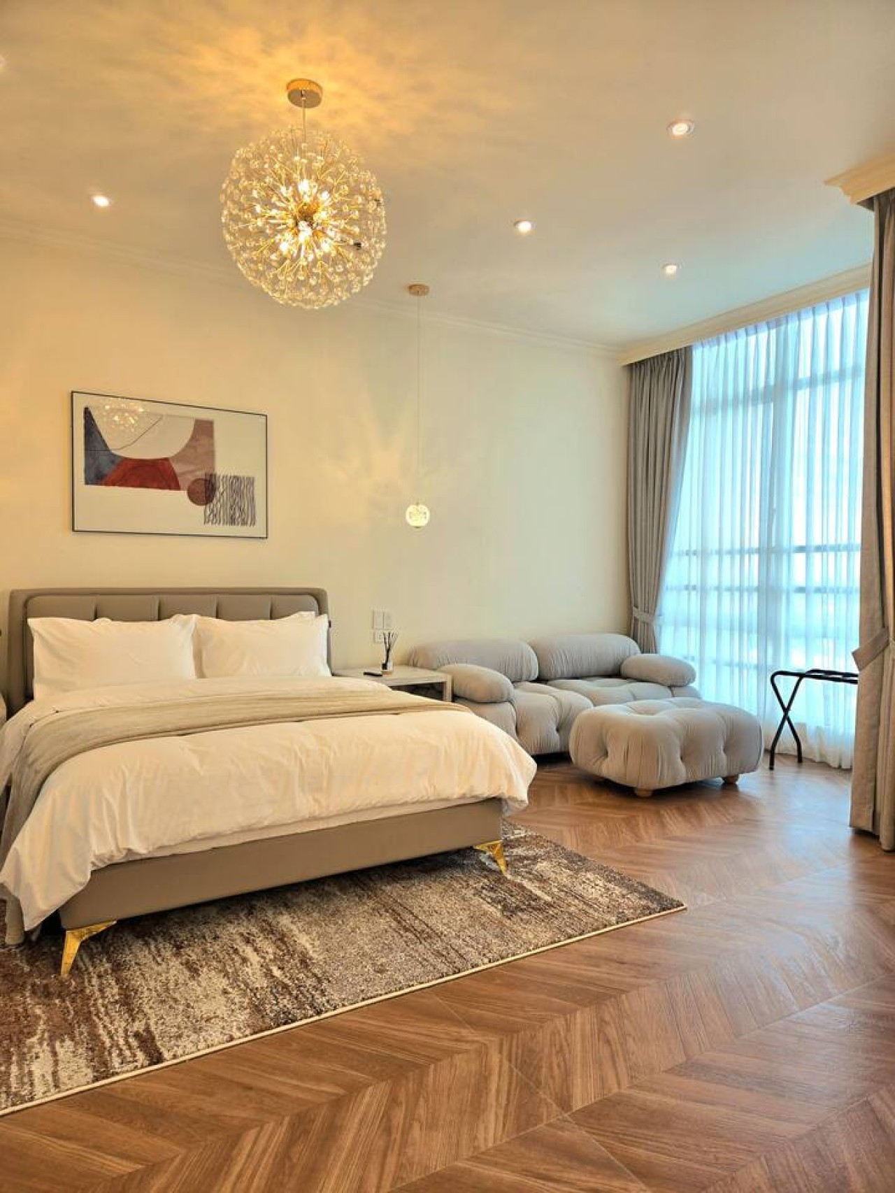 The main bedroom offers a cozy sofa, a study table, and a comfy queen bed with soft linens—perfect for a restful stay. It also features a private bathroom with a bathtub, shower, and water heater for a relaxing and comfortable experience.