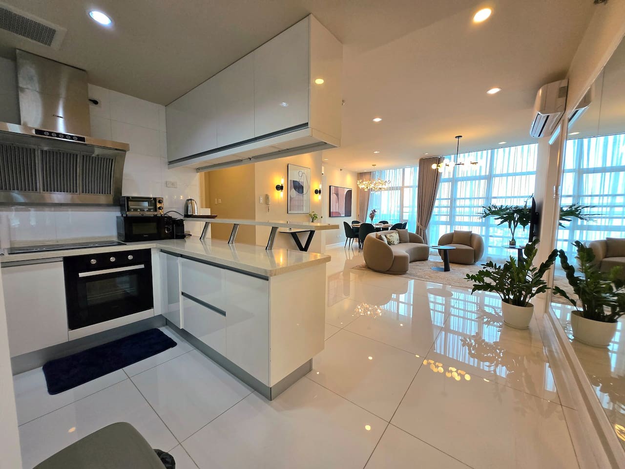 The kitchen features an open layout and is equipped with essential cooking items, cutleries, including an oven, coffee maker, and pots.