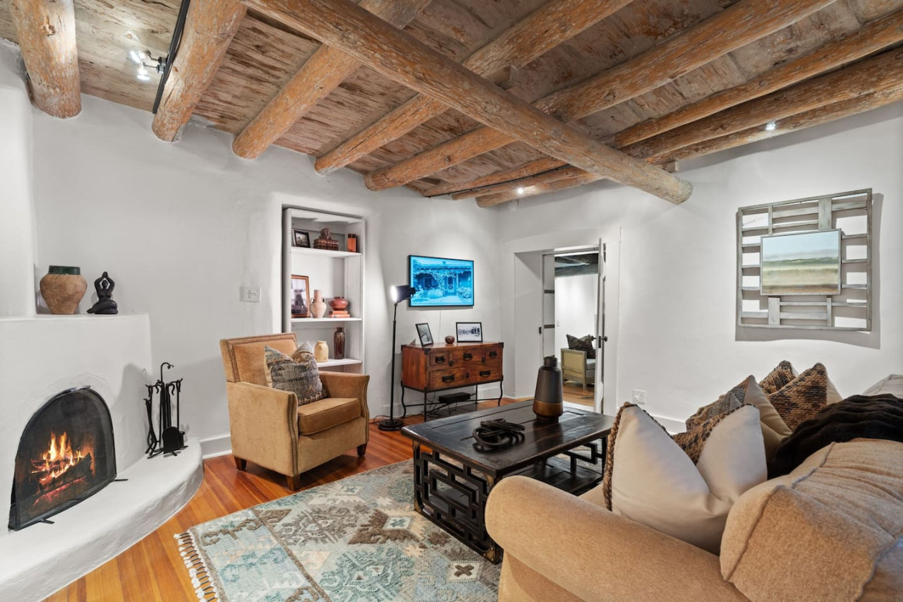 The casita living room with a fireplace and timber ceiling
