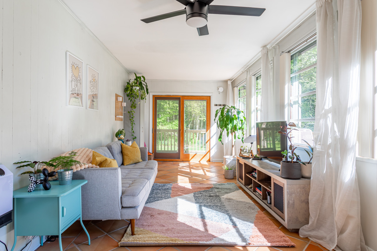 To the left of the sun room, a bright and airy living area with TV