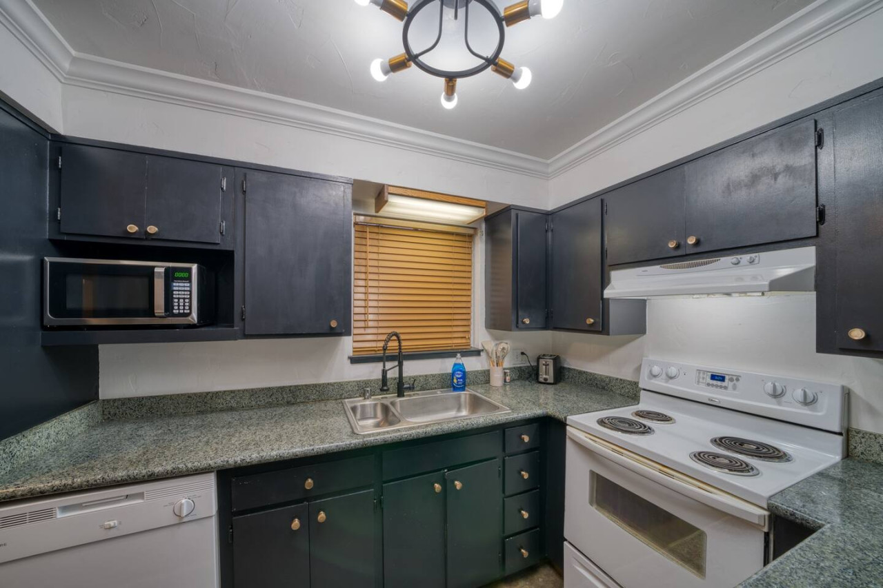 Kitchen with a four burner stove, oven and microwave.