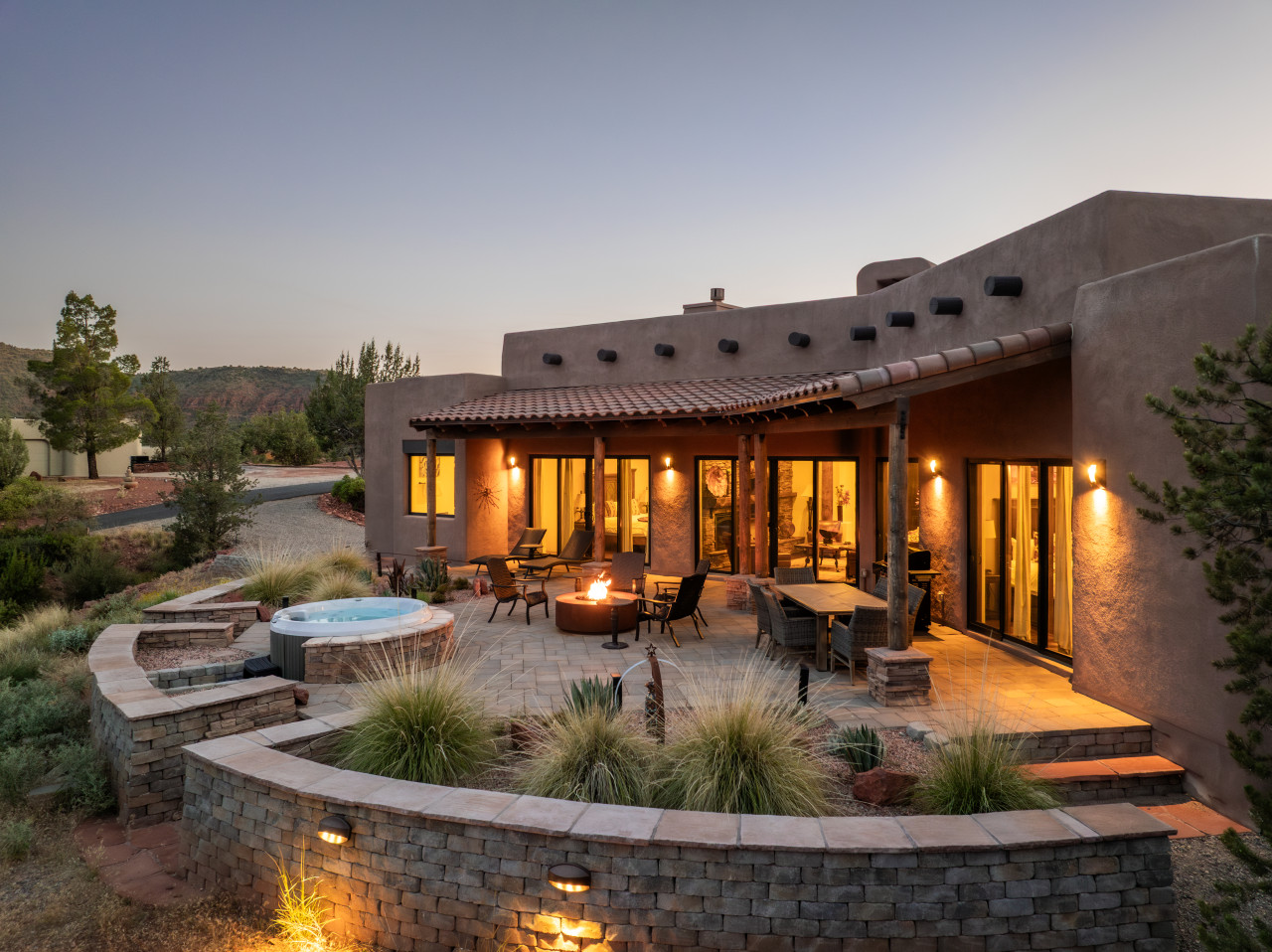 Adobe-style Sedona Airbnb with hot tub, firepit, and cozy patio lighting.