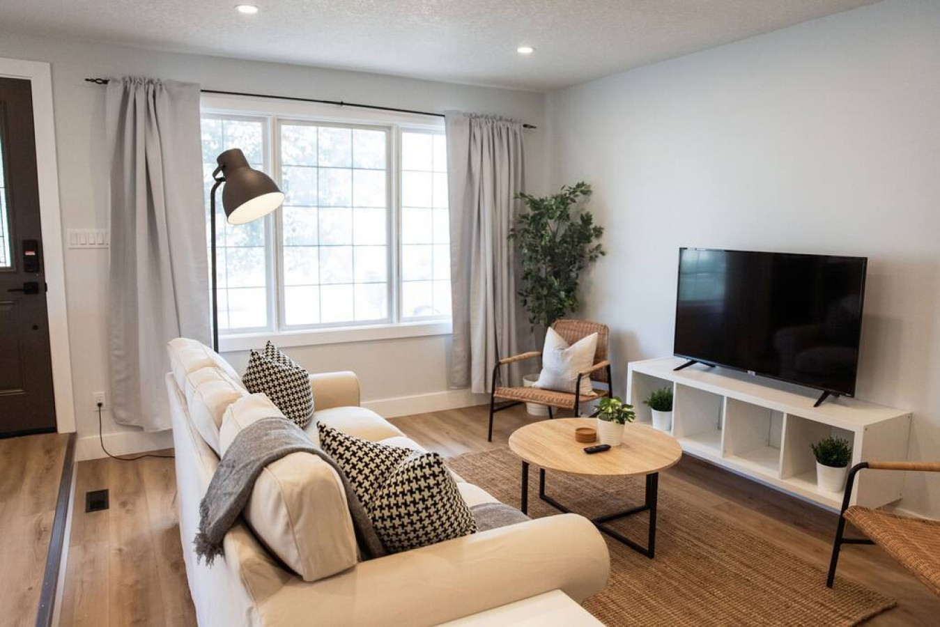 Bright and airy living room with plush seating, a large TV, and tasteful decor, creating the perfect space for relaxation and entertainment.