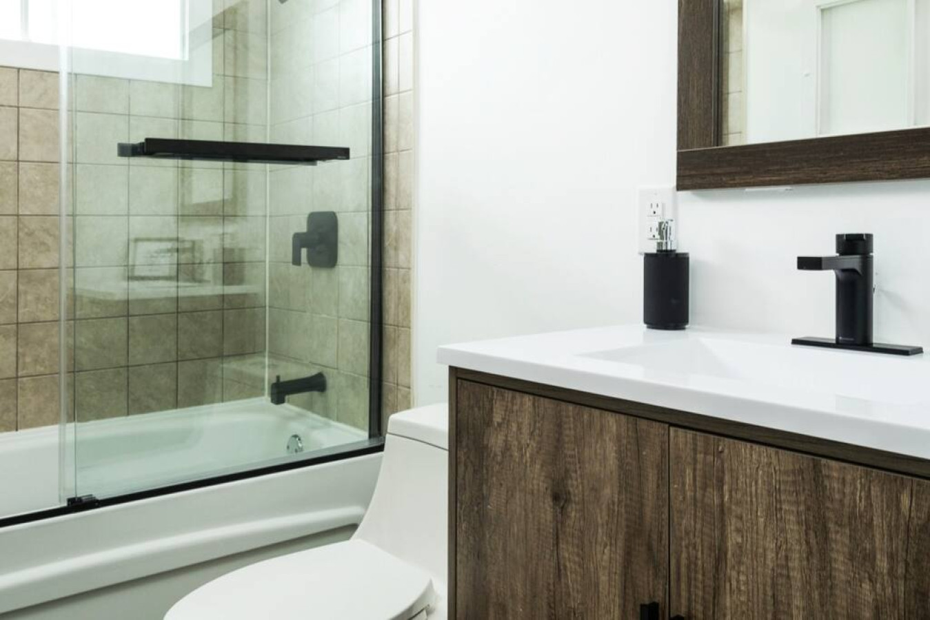 Modern bathroom with new glass shower door and black hardware