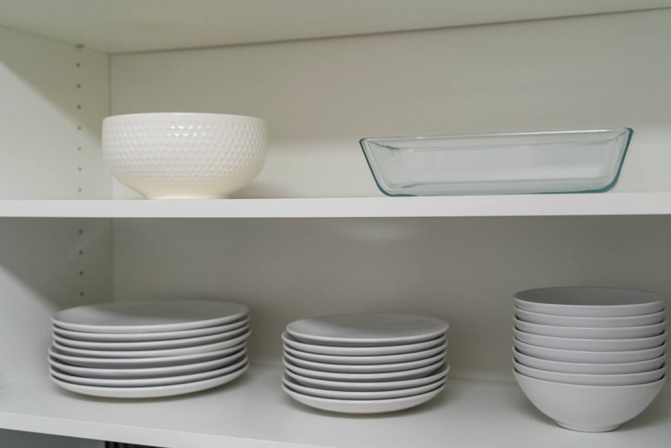 Kitchen cabinets stocked with cooking wares, glassware and silverwares, ideal for mixing up your favorite meals and drinks during your stay.