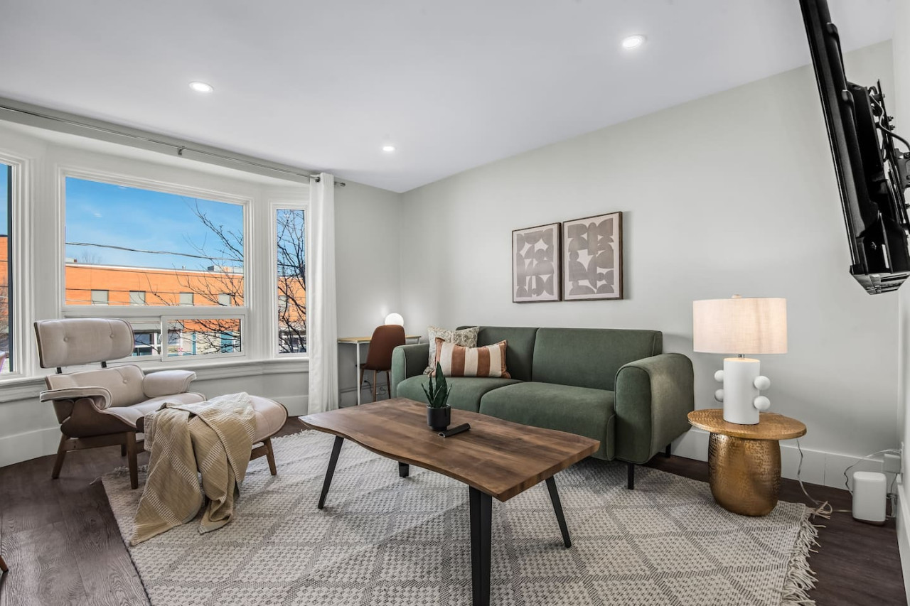 The living room’s cozy vibe makes it the perfect spot to relax, with ample seating and a warm ambiance.