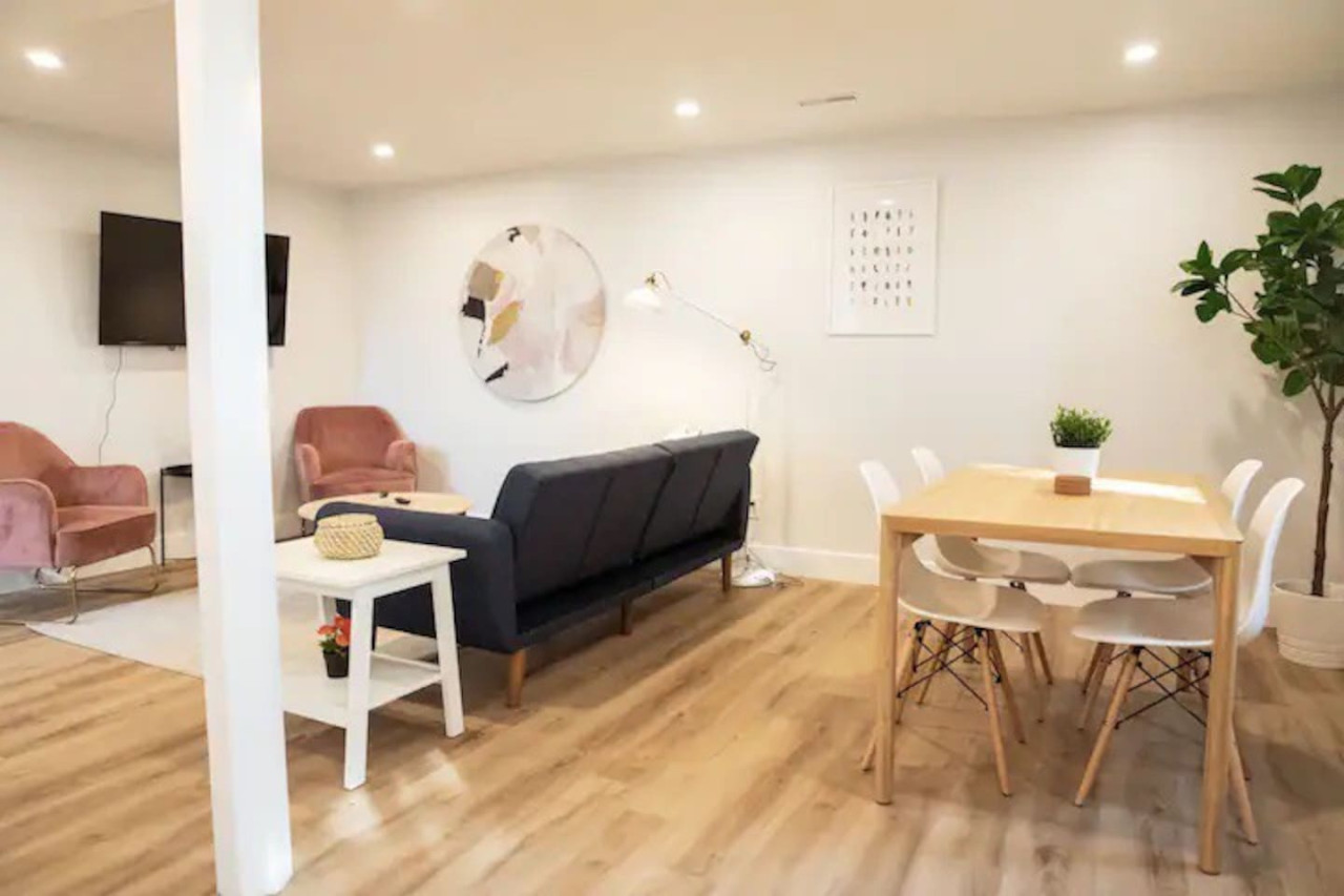 Spacious open-concept living and dining area featuring a vibrant sofa, modern furnishings, and a stylish entertainment setup—ideal for gatherings and relaxation.