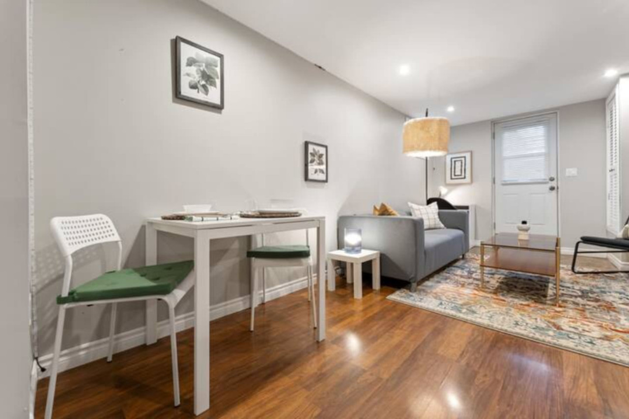 Spacious open-concept living and dining area featuring a vibrant sofa, modern furnishings, and a stylish entertainment setup—ideal for gatherings and relaxation.