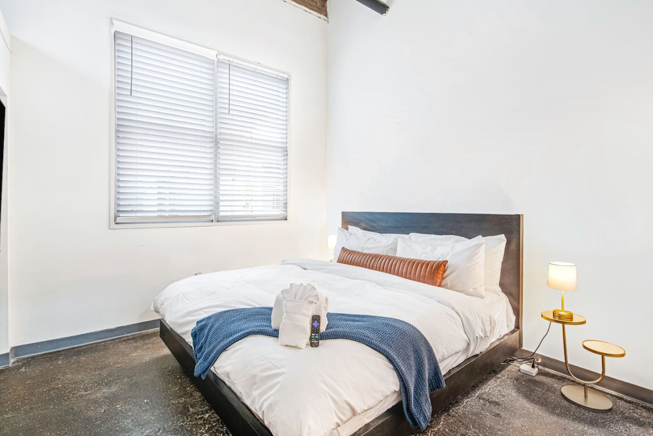 Guest bedroom with a King bed, Italian linens, plush robes, 40in TV, & dedicated workspace.