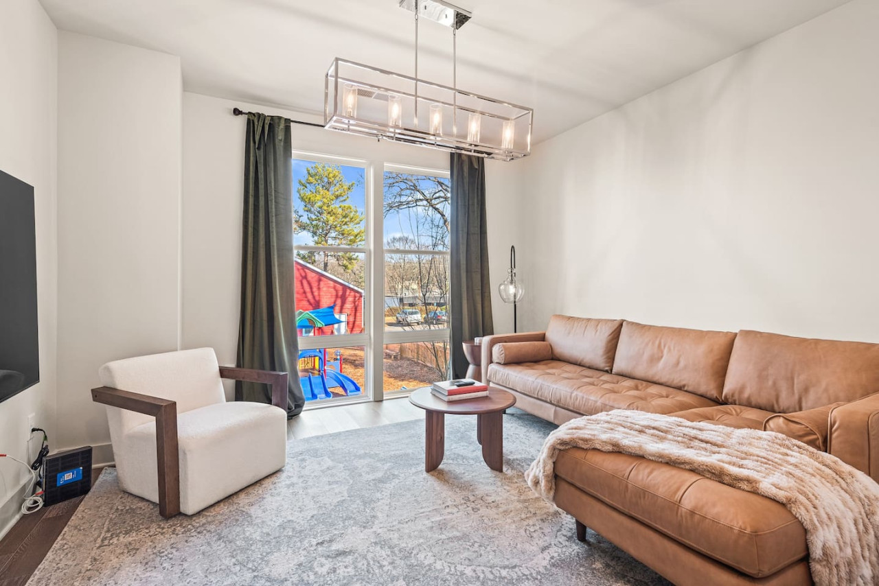 Sectional couch with a smart TV & curtains for privacy.