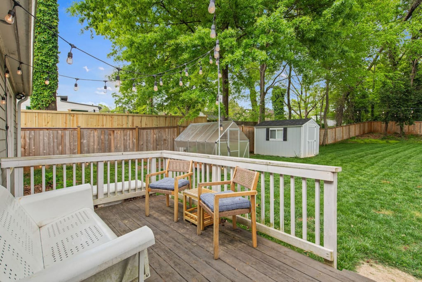 Additional deck adorned with string lights with outdoor seating, access to fire pit and hammock.