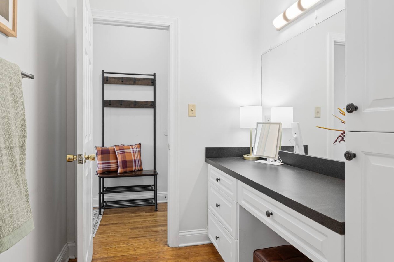 This angle highlights the spacious vanity area, perfect for getting ready in the morning or winding down in the evening. The well-lit counter provides plenty of space, while the adjacent seating nook adds a cozy touch for convenience and comfort.