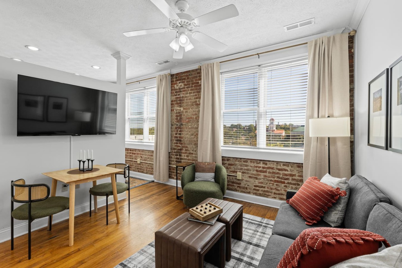 Bright and airy, this living space boasts large windows with scenic views and exposed brick for a touch of charm. Enjoy movie nights on the mounted flat-screen TV or a cozy meal at the intimate dining table for two.
