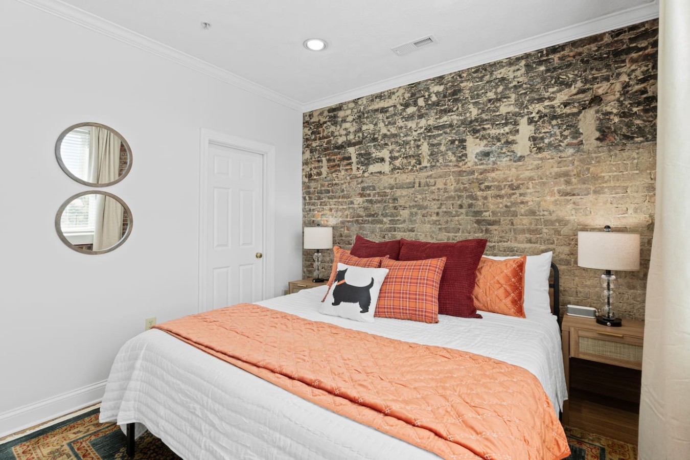 Relax in the comfort of a spacious king-size bed, surrounded by charming exposed brick walls that give the room a cozy, historic feel. The colorful pillows and décor add warmth, making this the perfect spot to unwind after a day of exploring Maryvill