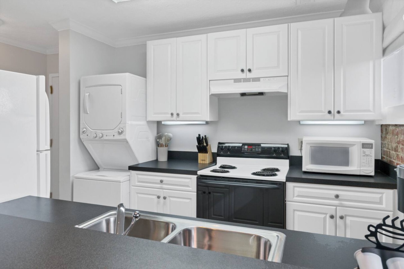 Convenient and inviting kitchen area with all the essentials, including a refrigerator, dishwasher, and coffee station. Ideal for enjoying home-cooked meals or quick snacks.