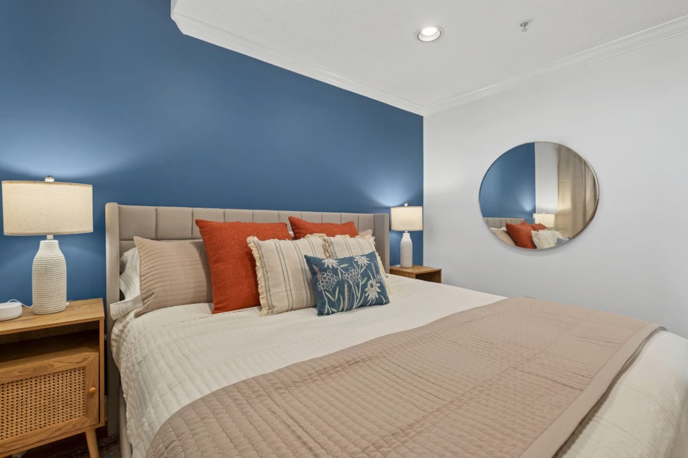 Relax in this beautifully designed bedroom featuring a plush king-size bed, stylish accent pillows, and modern decor. The deep blue accent wall and soft lighting create a cozy, inviting atmosphere for a restful stay. Perfect for a Maryville getaway!