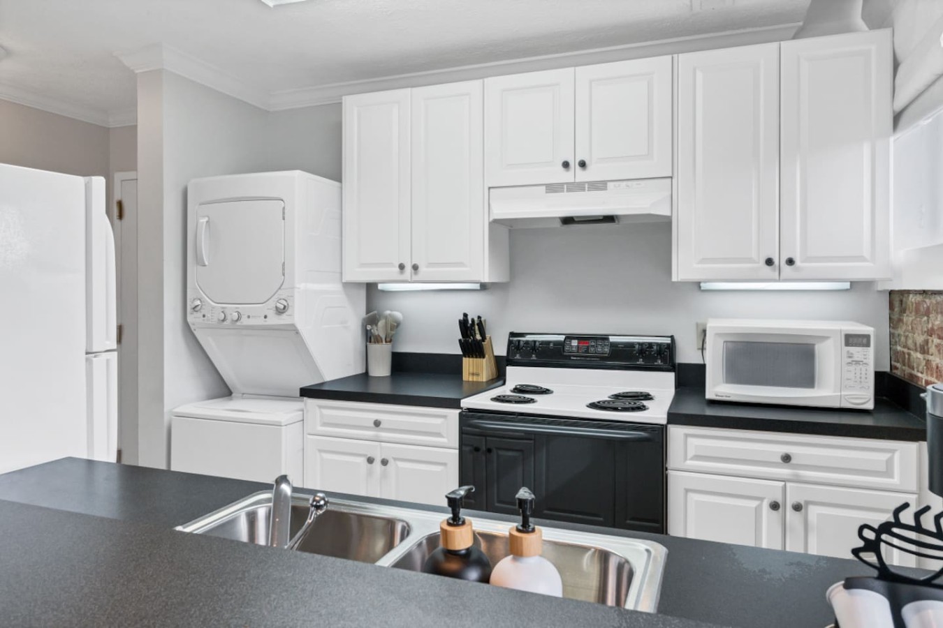 Bright and functional kitchen with modern amenities, including a Keurig coffee maker, dishwasher, washer and dryer, and ample counter space. Perfect for preparing meals, tackling laundry, or enjoying a morning coffee.