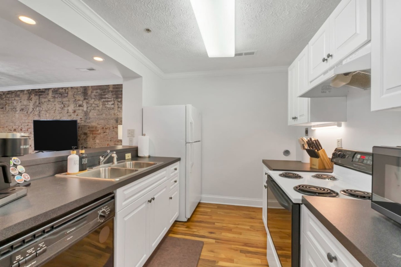 Bright fully equipped kitchen with modern appliances, ample counter space, and all essentials for cooking. Enjoy a hassle-free stay in downtown Maryville with everything you need for home-cooked meals.
