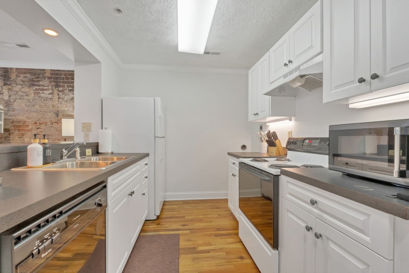 Fully equipped kitchen with modern appliances, ample counter space, and all the essentials for home-cooked meals. Enjoy a seamless cooking experience in this bright, open-concept space with a view of the cozy living area.