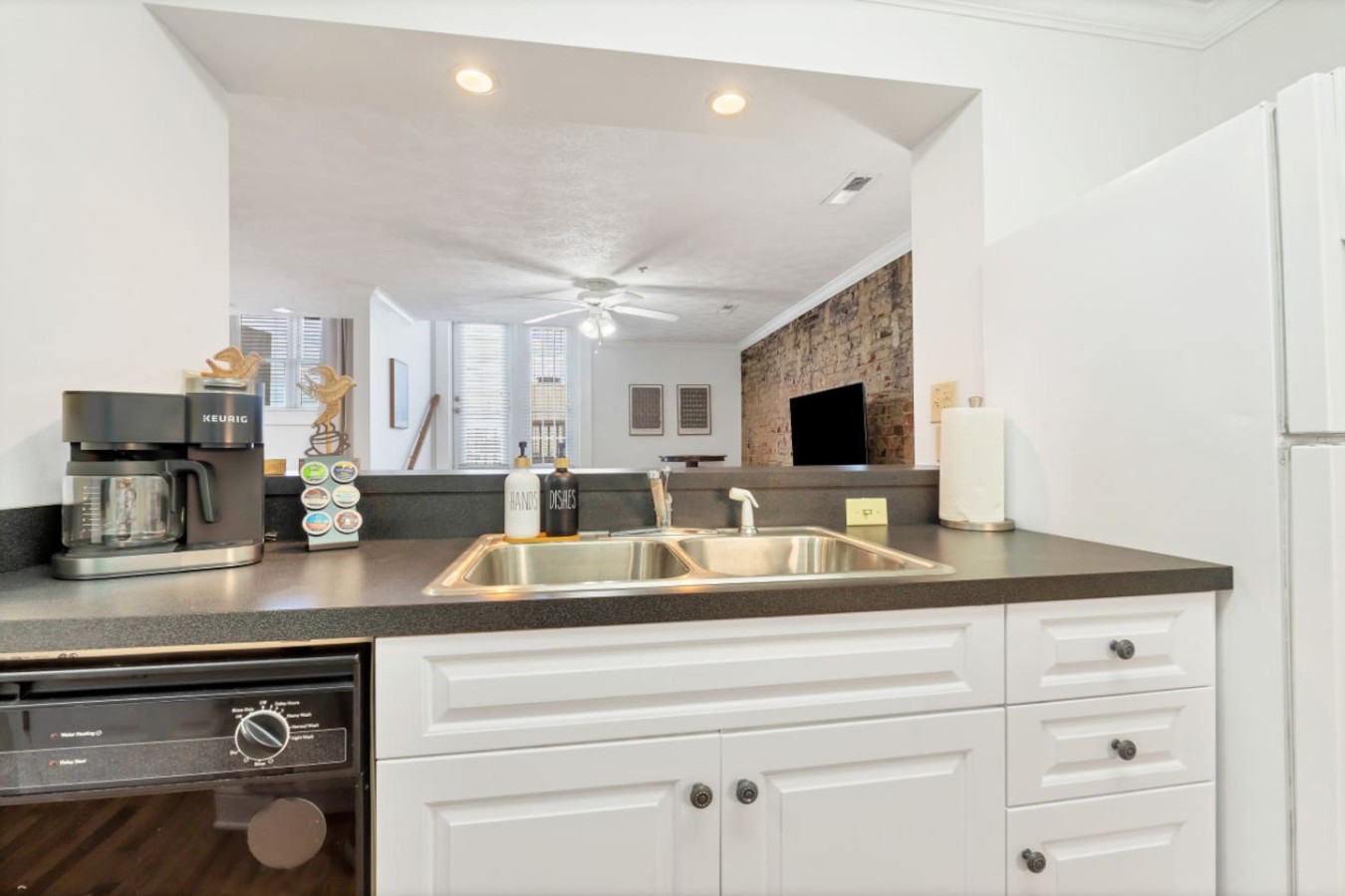 Open-concept kitchen with double sink, coffee station, and modern appliances. Overlooks the cozy living space, making meal prep and socializing effortless. Fully stocked with essentials for a comfortable stay in downtown Maryville.
