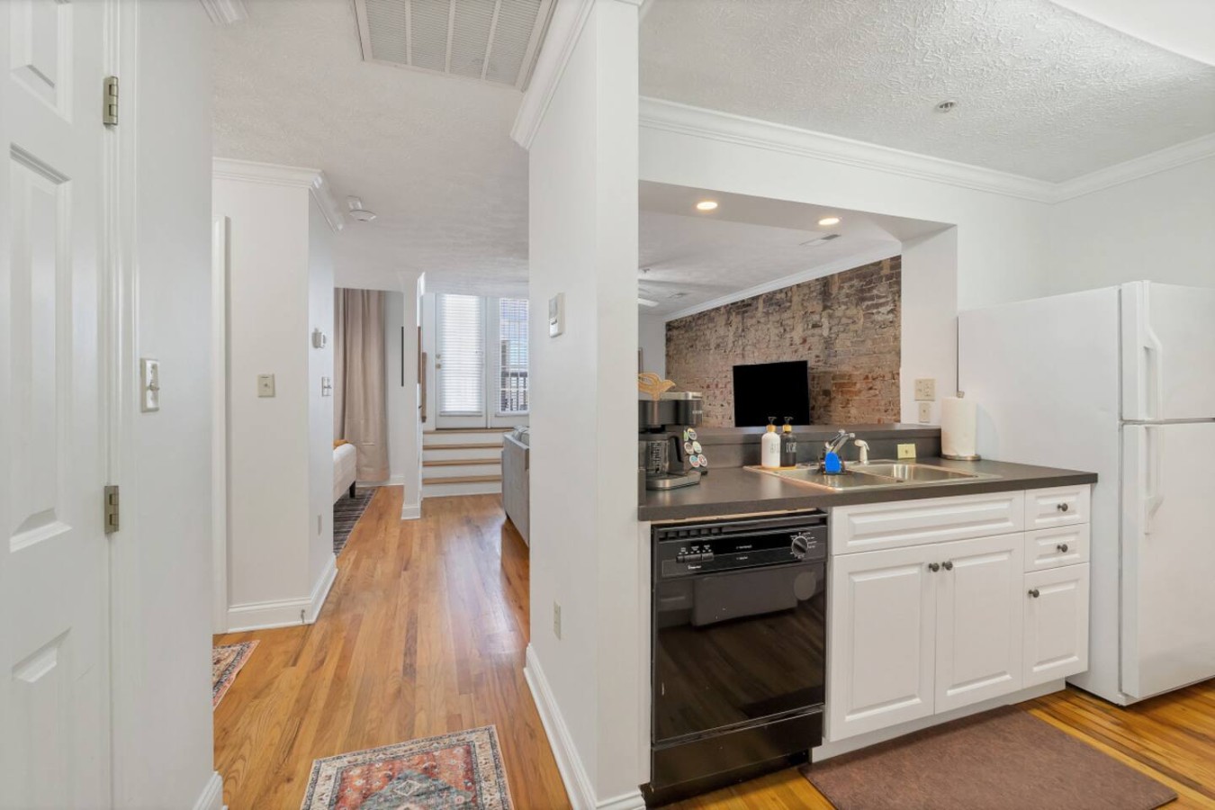 Open-concept layout with a fully equipped kitchen, hardwood floors, and natural light. Enjoy easy access from the kitchen to the cozy living area, perfect for entertaining or relaxing after a day exploring downtown Maryville.