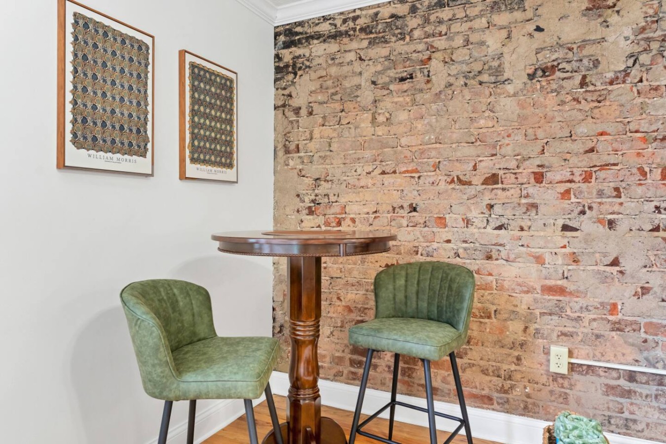 Charming bistro-style seating with plush green chairs and an exposed brick accent wall. Perfect for morning coffee, casual meals, or a cozy workspace in the heart of downtown Maryville.