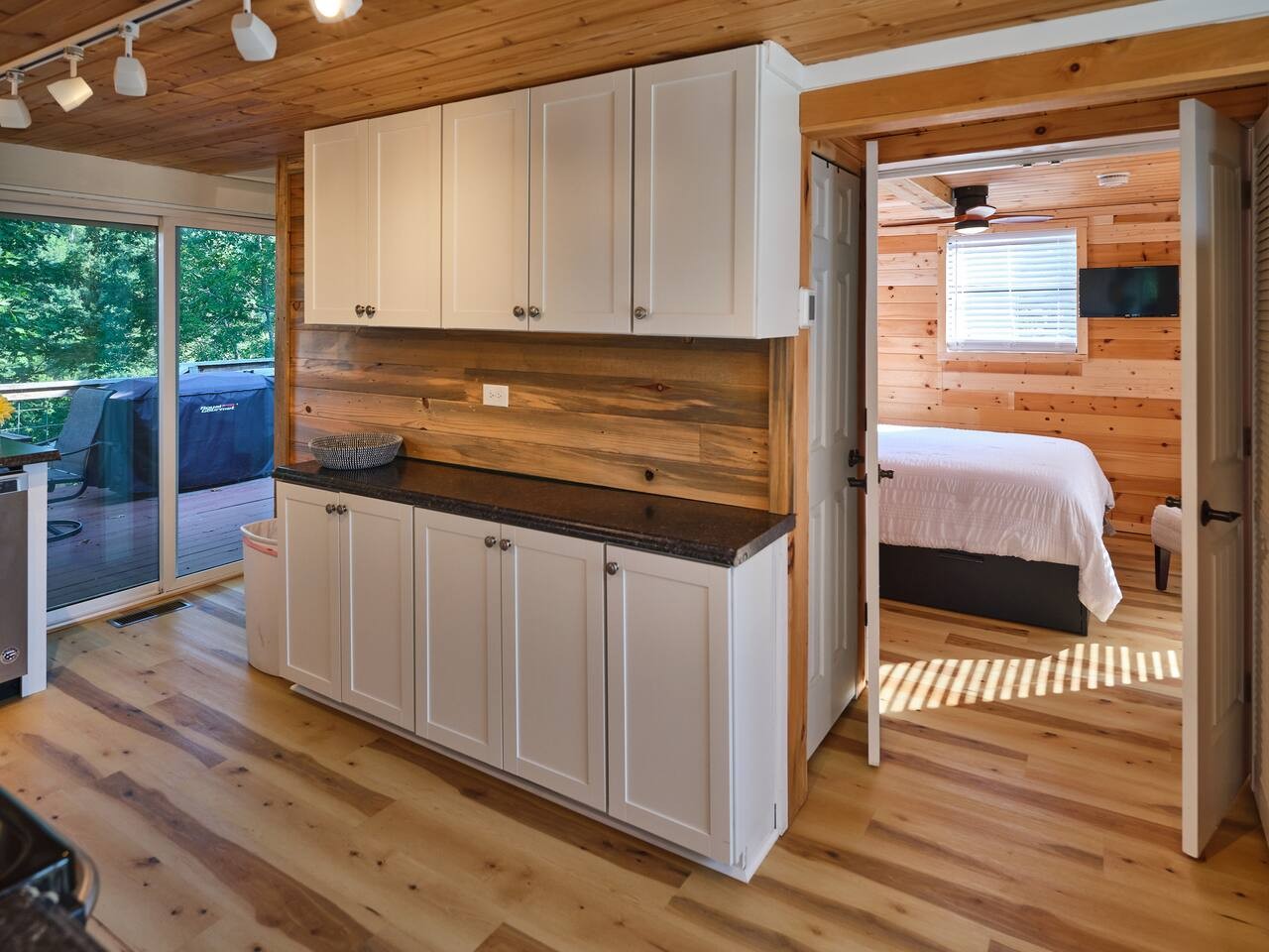 The master bedroom is located beside the kitchen. The bathroom is located around the corner from the sliding doors.