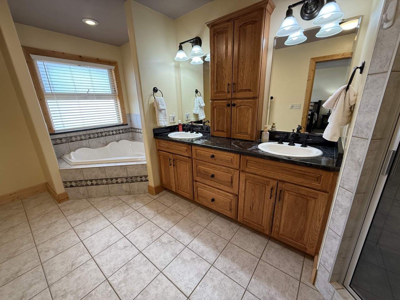Attached master bathroom with large tub and shower