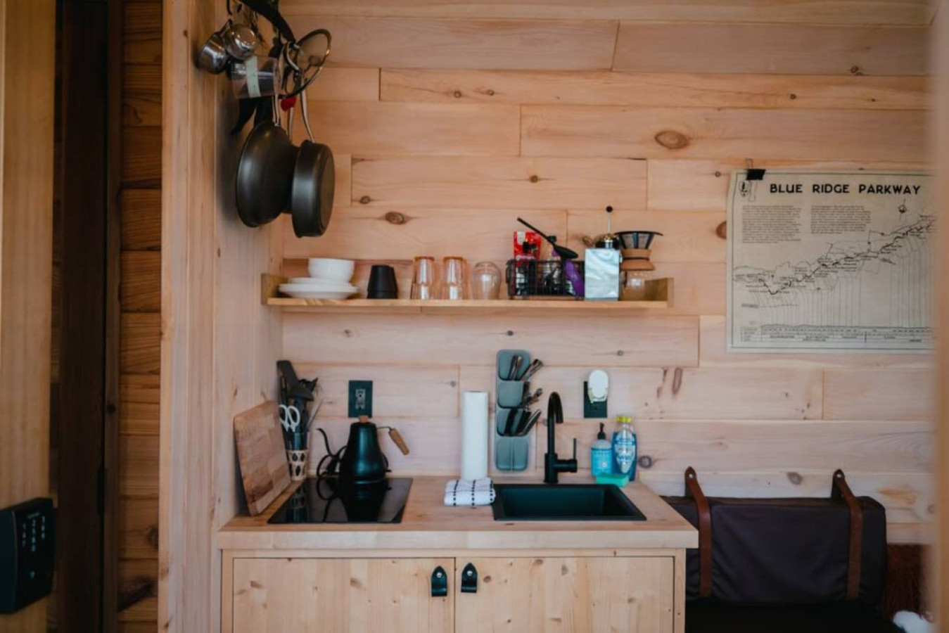 The small yet functional kitchen features a pour over and French press with a local coffee selection and an induction cooktop, microwave, and other essentials for a quick meal.