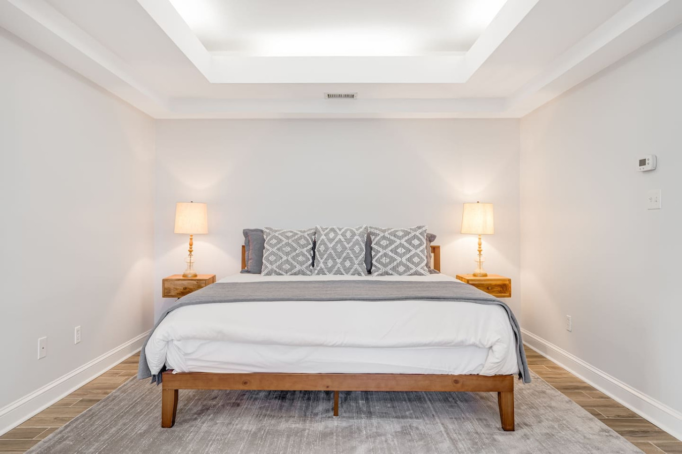Primary bedroom suite with attached bathroom, king bed, TV, and lounge area.