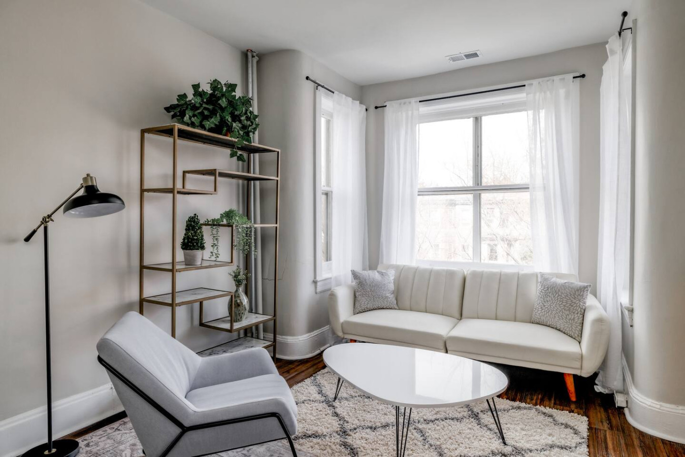 This living room, featuring plush white couches and a stylish coffee table, is the perfect place to relax and unwind.